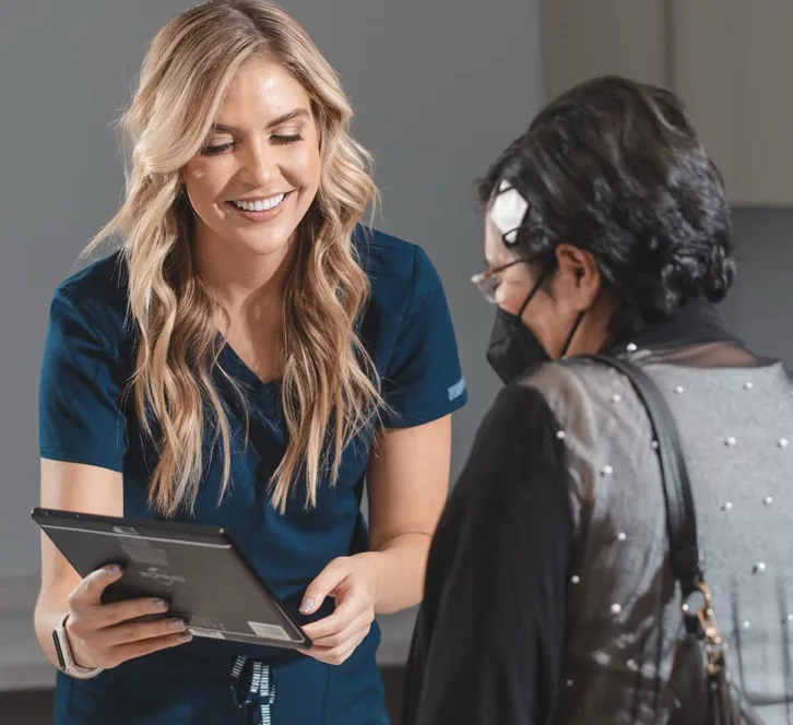 A staff member showing a patient information on a tablet